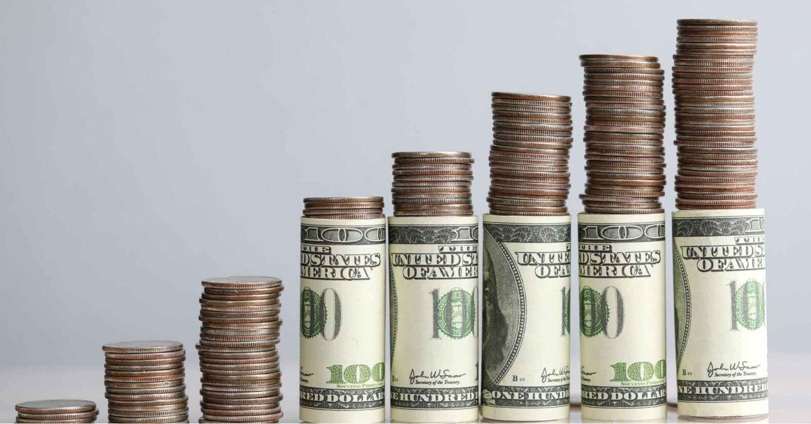 Stacked coins and rolled cash