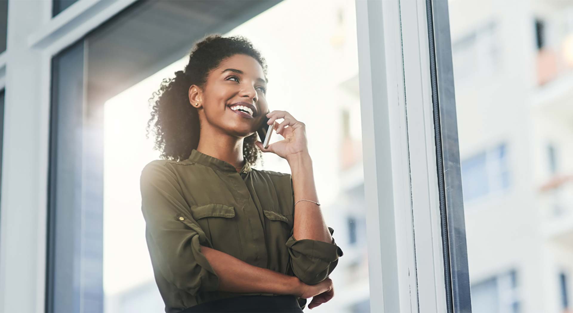 Woman on a phone in an office near the windows